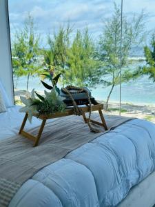 a swing on the beach with a table with flowers at Lazzlla beach front apartments in Hulhumale