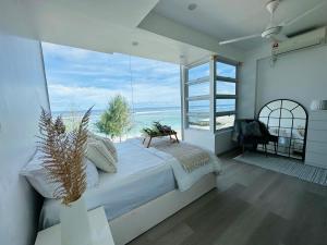 um quarto com uma cama grande e uma janela grande em Lazzlla beach front apartments em Hulhumale