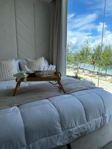 a bed in a room with a view of the beach at Lazzlla beach front apartments in Hulhumale