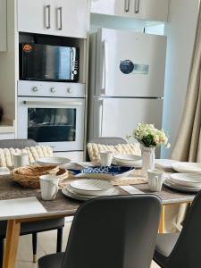 a kitchen with a table with plates and appliances at Lazzlla beach front apartments in Hulhumale