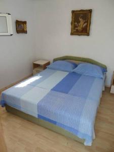 a bedroom with a blue bed with blue pillows at Apartment Ljilja in Blato