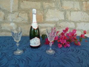a bottle of champagne and two glasses on a table at Apartment Ljilja in Blato
