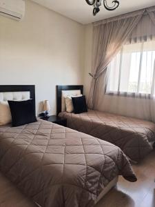 - une chambre avec 2 lits et une fenêtre dans l'établissement Prestigia golf pour les familles, à Marrakech