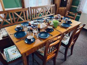 a wooden table with plates and dishes on it at Pension Jaruska in Špindlerův Mlýn