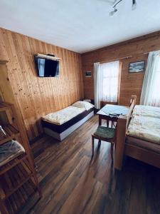 Habitación con 2 camas y mesa. en Pension Jaruska en Špindlerův Mlýn