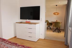una sala de estar con TV en una cómoda blanca en Junker's Apartments, en Salzburgo