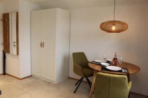 jadalnia ze stołem i zielonymi krzesłami w obiekcie Junker's Apartments w mieście Salzburg