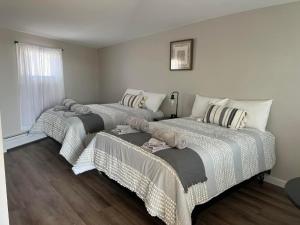 2 łóżka w pokoju z drewnianą podłogą w obiekcie Lincoln House Motel w mieście Lincoln