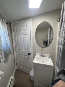 una persona que toma una foto de un baño con espejo en Lincoln House Motel en Lincoln