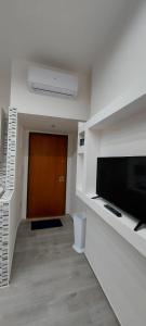 a living room with a flat screen tv and a door at La Maison d'Annette in Lavello +3 photos