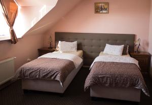 1 dormitorio con 2 camas y escalera en Penzión ROYAL, en Bytča