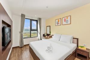 een slaapkamer met een groot wit bed en een raam bij S Lux Apartment Virgo in Nha Trang