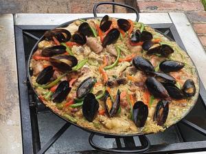 a pizza with mussels on it sitting on a grill at La Estancia de la Pradera Cabana Fiba in Nobsa