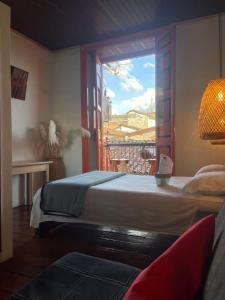 a bedroom with a bed and a window with a balcony at Hotel Colonial Abejorral in Abejorral