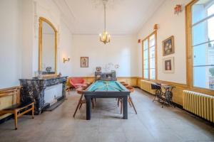 - un salon avec une table et une cheminée dans l'établissement Le Manoir du Belvédère - Piscine/Baby-Foot/Billard, à Castries