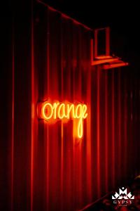 a neon orange sign on the side of a curtain at Gipsy Village Park Hotel in Asuretʼi