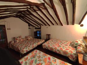 a bedroom with two beds and a ceiling with beams at Los limones in Villanueva de Algaidas