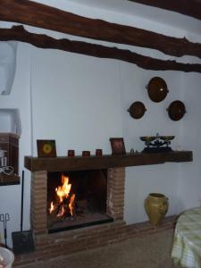 a fireplace in a living room with a fire at Los limones in Villanueva de Algaidas