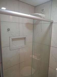 y baño con ducha y puerta de cristal. en Hotel Apiacas, en Ribeirão Preto