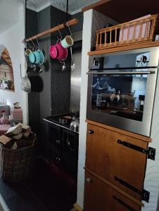 a kitchen with a stove and a large entertainment center at Landwohnung Max&Fritz in Schauenstein