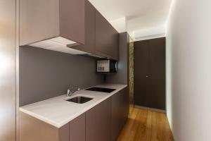 a kitchen with a sink and a microwave at Pensao O Laranjeira in Viana do Castelo