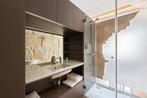 a bathroom with a sink and a glass shower at Pensao O Laranjeira in Viana do Castelo