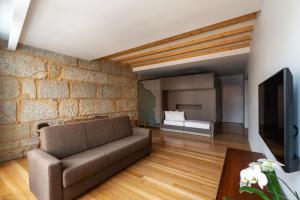 a living room with a couch and a brick wall at Pensao O Laranjeira in Viana do Castelo