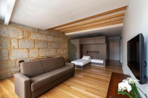 a living room with a couch and a brick wall at Pensao O Laranjeira in Viana do Castelo