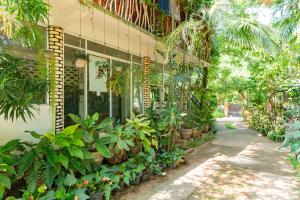 Green Garden Resort في هارابانا: مبنى به مجموعه من النباتات خارجه