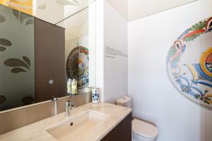 a bathroom with a sink and a mirror at Pensao O Laranjeira in Viana do Castelo