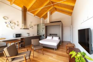 a bedroom with a bed and a kitchen with a table at Pensao O Laranjeira in Viana do Castelo