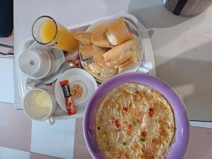 - un plateau de nourriture avec une tarte et une assiette de pain dans l'établissement Residence MaryHouse, à Cotonou