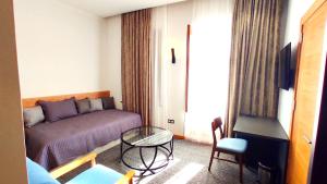 Zimmer mit einem Bett, einem Tisch und einem Sofa in der Unterkunft Apart Hotel Banovani in Tbilisi City
