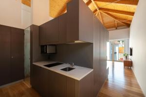 a kitchen with brown cabinets and a sink at Pensao O Laranjeira in Viana do Castelo