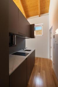 a kitchen with gray cabinets and a wooden floor at Pensao O Laranjeira in Viana do Castelo