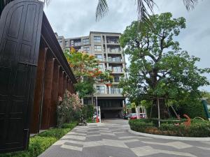 a building with a tree in the middle of a sidewalk at La Habana HuaHin by ABCD in Hua Hin