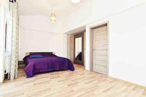 a bedroom with a purple bed and a wooden floor at Casa Albert 3 in Iaşi