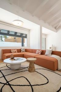 a living room with a couch and a table at Villa Tropico - Design house with pool in Corralejo in Corralejo +37 photos