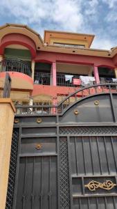 a building with a black door and a balcony at Chayil Loft Mulago in Kampala