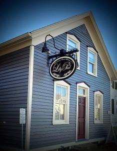 a sign on the side of a blue house at Lilly Pad in Cedarburg