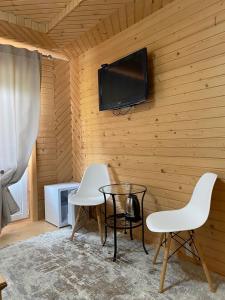 a room with two chairs and a table and a tv on a wall at Villa Filiak in Yablunytsya