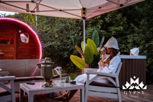 a woman sitting in a chair talking on a cell phone at Gipsy Village Park Hotel in Asuretʼi