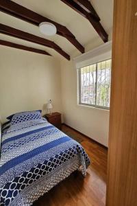 um quarto com uma cama com um edredão azul e branco em Casa muy bien ubicada cercana al metro y a mall em Santiago