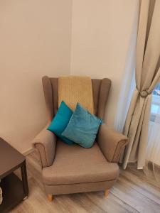 a chair with two blue pillows in a room at Z-1 Kraków Old Town O&P ApartFamily in Kraków