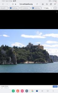 a picture of a castle on a hill in the water at Appartament holidays Sistiana in Sistiana