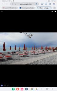 vista su una spiaggia con sedie e ombrelloni di Appartament holidays Sistiana a Sistiana