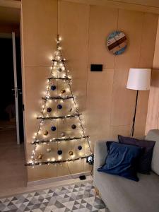 un árbol de Navidad con luces en la sala de estar en A tiny house with a garden and a hot tube en Pringi