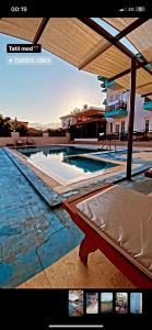 a swimming pool with a bed in front of a building at Tekirova Dora butik otel in Kemer