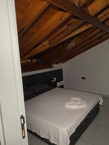 a bedroom with a bed with a wooden ceiling at Tekirova Dora butik otel in Kemer