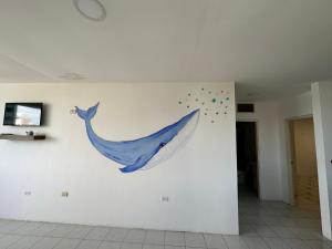 una pared con una ballena azul pintada en ella en My place in paradise, en San Cristobal